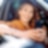 Image shows a woman using her phone when her car is stationary.