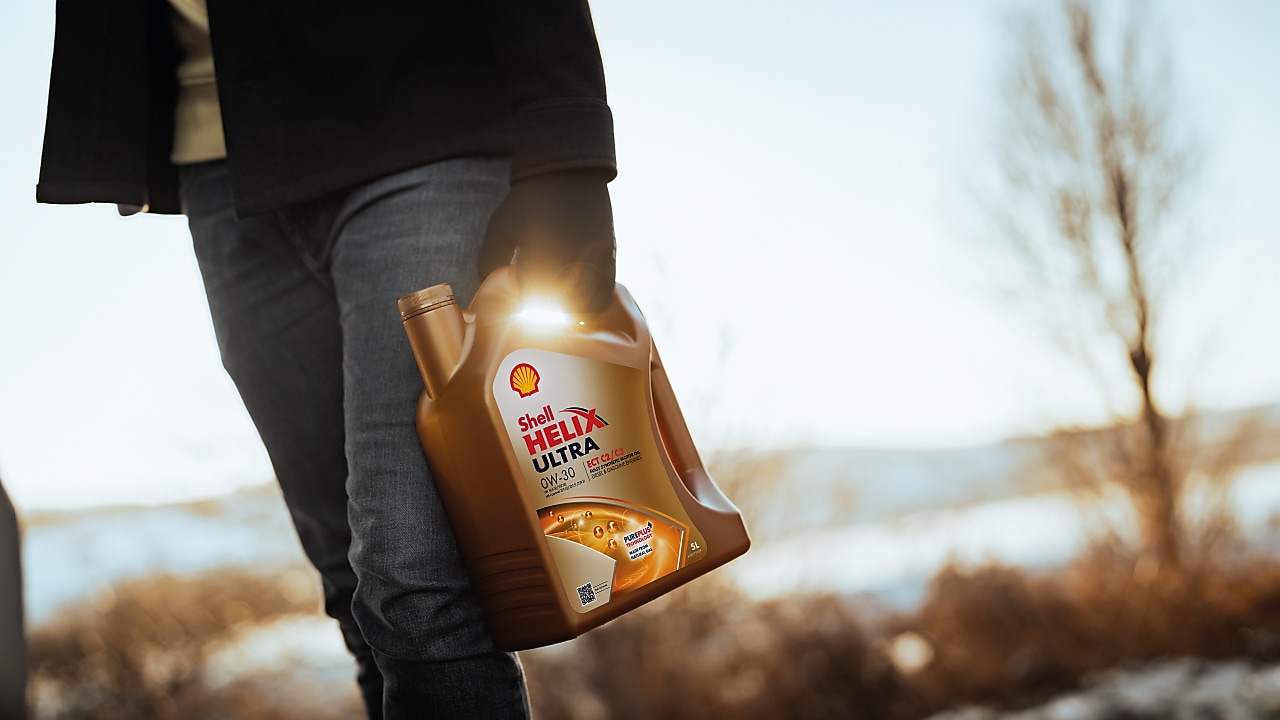 Άνδρας κρατά μπουκάλι Shell Helix Ultra