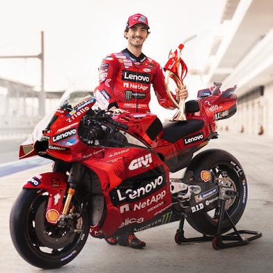 Ducati Corse team leaning on Ducati Motorbike.