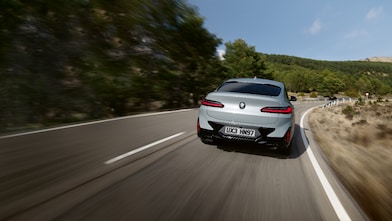 Ασημί BMW με τον άνθρωπο να μπαίνει σε αυτό από ψηλά