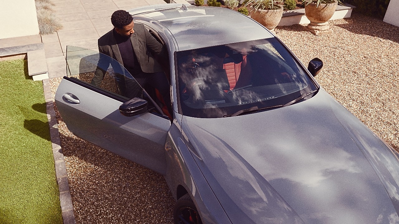 Ασημί BMW με τον άνθρωπο να μπαίνει σε αυτό από ψηλά